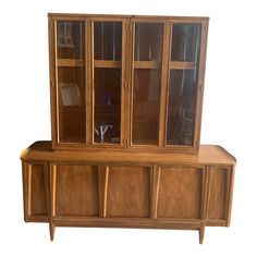 a wooden cabinet with glass doors and drawers