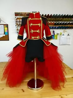 a red and black tulle skirted dress on a mannequin head stand