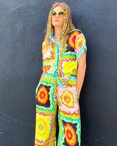 Get ready to stop traffic with this fabulous, conversation starting, compliment demanding button front blouse. Featuring a groovy, 60's inspired all-over print placement sunflower pattern, these vibrant pants are perfect for all of your fabulous festivities. With a relaxed, loose fit, these elastic waist pants are stylish and ultra comfortable. The drawstrings feature colorful beads for a dramatic touch. The roomy side seam pockets are perfect for carrying all your essentials and make these pant Sunflower Pattern, Print Placement, African Safari, Elastic Waist Pants, Spiritual Jewelry, Party Girls, Waist Pants, Flare Pants, Jacket Tops