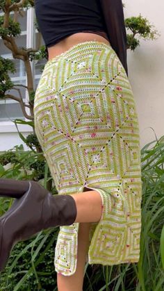 a woman in high heels is leaning against a wall with her hand on her hip