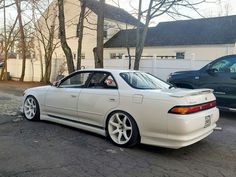 a white car parked in front of a house