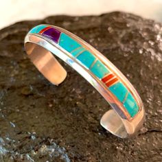 Gorgeous Classic Navajo Bracelet Handcrafted By 2 Known Master Artists Rose Ann Long And Calvin Begay. Beautiful Quality Channel Inlay Work With Rich Colors Of Turquoise, Red Coral And Sugilite. Native American Southwest Size 6 1/4” Total Inside Circumference Which Includes 5” Cuff Plus A Gap Of 1 1/4” Weighs 25.9 Grams 3/8” Wide Signed Hallmarks Rose Ann Long And Calvin Stamped Sterling New Condition Never Worn From Vintage 80’s Collection B157 Southwestern Style Blue Inlay Bracelets, Southwestern Sterling Silver Cuff Bracelet In Blue, Multicolor Inlay Sterling Silver Bracelets, Multicolor Sterling Silver Bracelet With Inlay, Multicolor Sterling Silver Bracelets With Inlay, Traditional Blue Sterling Silver Bracelets, Southwestern Multicolor Bracelets With Inlay, Southwestern Style Sterling Silver Bracelet, Southwestern Silver Multi-stone Bracelets