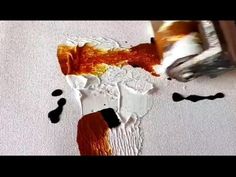 a person is painting on the floor with orange and black paint