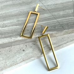 New~ Anthropologie Gold Rectangle Silhouette Earrings This Is A Perfect Pair Of Earrings To Add To Your Collection. Their Elegant And Modern Design Is Timeless. Suspended From A Tiny Gold Rectangle, A Larger See Through Golden Frame Dangles Below Reflecting Light From All Surfaces. With Their Long Silhouette And Clean Lines, These Can Be Worn Anytime. Approx. Size, 2-1/4"L, 1/2" W. Gold Plated, Nwot. Anthro Style, Boho Style, Trendy, Brand New Anthropologie Jewelry, Everyday Hoop Earrings, Gold Everyday Modern Rectangular Linear Earrings, Modern Rectangular Earrings For Party, Chic Rectangular Earrings As Gift, Chic Rectangular Earrings For Gift, Modern Rectangular Party Earrings, Gold Rectangular Linear Earrings For Everyday, Elegant Rectangular Linear Earrings For Gift, Elegant Rectangular Linear Earrings As Gift, Chic Rectangular Earrings For Everyday