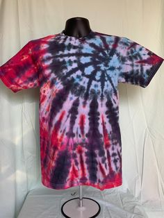 a tie - dyed t - shirt on a mannequin stand with white backdrop