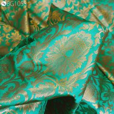 green and gold brocaded fabric with large flowers on it's side, close up