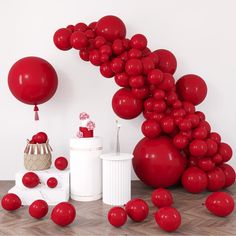 a bunch of balloons that are on the ground near a cake and some other items