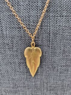 This nature-inspired handmade solid leaf necklace has an 18-inch gold-plated chain and clasp, with a 3cm/1.18-inch leaf pendant- an excellent accessory for any Fall outfit. Leaves symbolize growth and rebirth. Gift the earrings and necklace set to a new graduate in the family or show your support to someone going through significant changes in their life. Necklace measurements: Chain Length: 18 inches / 45.72cm Pendant: 1.18 inches / 3cm Gold Leaf Nature-inspired Jewelry, Nature-inspired Gold Leaf-shaped Jewelry, Gold Leaf-shaped Nature-inspired Necklace, Gold Nature-inspired Necklace With Large Pendant, Nature-inspired Gold Teardrop Pendant Jewelry, Nature-inspired Gold Leaf Necklace, Nature-inspired Leaf-shaped Brass Jewelry, Vintage Gold Leaf Jewelry, Vintage Gold Leaf-shaped Jewelry