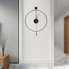 a clock is on the wall next to a vase with flowers in it and an open door