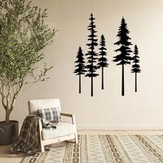 a living room with a chair, rug and wall decals that have trees on them