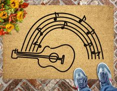 a person standing in front of a door mat with a guitar on it