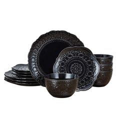 a set of black dinnerware with ornate designs