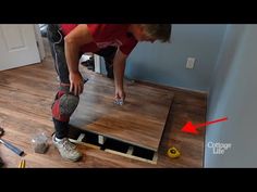 a man in red shirt working on wooden floor