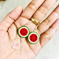 watermelon slices are being held in someone's hand with scissors on it