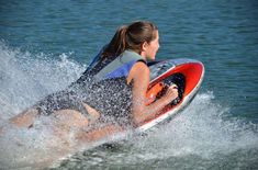 a woman riding on top of a jet ski in the water