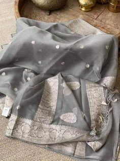 This is a traditional pure banarasi woven georgette saree in beautiful grey colour with an amazing zari weave. Saree features elegantly floriated zari border and pallu. The floral bootis is run throughout the body of the saree. The pallu has paisley bootis in zari weave, the pallu is finished with skill full tassels, which makes it more beautiful. Georgette gives a very beautiful drape owing to its flowy nature. Color: Grey Length: 5.5 Meters Width: 1.2 Meters Blouse: Running/attached blouse in Sheer Dupatta Traditional Wear For Diwali, Elegant Georgette Dupatta With Traditional Patterns, Traditional Organza Dupatta With Zari Weaving, Grey Saree, Khadi Saree, Floral Saree, Lehenga Designs Simple, Organza Silk Saree, Beautiful Dress Designs