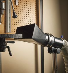 a microphone attached to a wall mounted on a metal shelf in front of a workbench