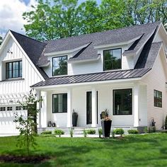 a large white house sitting on top of a lush green field