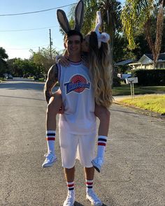 a man and woman in bunny ears are standing on the street with their arms around each other