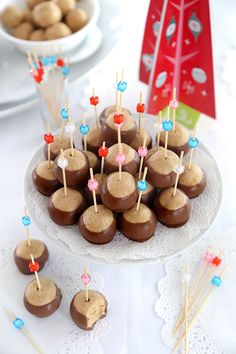 there are chocolates and marshmallows on the plate with toothpicks