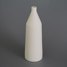 a white vase sitting on top of a table