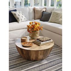 a living room filled with furniture and flowers on top of a wooden table in front of a white couch