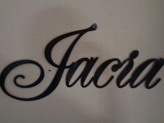 the word fascia written in cursive black metal letters on a white wall