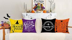 a couch with halloween pillows on it in front of a white table and pumpkins