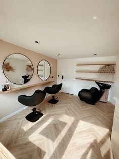 an empty room with chairs and mirrors on the wall, in front of a shelf