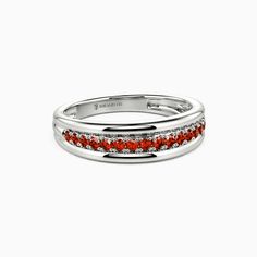 a white gold ring with red stones in the center and two rows of diamonds on each band