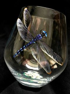 a dragonfly sitting on top of a glass bowl