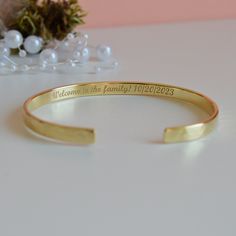 "Looking for the new daughter in law gift? Our \"Welcome to the family\" bracelet makes a great memento from Mother/Father in Law. - Laser engraving up to 90 characters on each side  - Coated with 22K gold and the thickness of the gold layer is 0.5 microns  - Text, coordinates, numbers or handwriting outside and inside the cuff  - Approximately 5mm wide, 1.2 mm thick - Laser engraved - the engraving is burned into the material using a laser beam.  SIZES: This is the length of the metal, not incl Engraved Gold Heirloom Bracelet For Wedding, Engraved Gold Bangle Bracelet For Anniversary, Engraved Heirloom Gold Bracelet For Wedding, Heirloom Gold Bracelet Engraved For Wedding, Heirloom Engraved Gold Bracelet For Wedding, Anniversary Engraved Gold Bangle Bracelet, Yellow Gold Engraved Bracelet For Wedding, Gold Jewelry With Hallmark For Wedding Gift, Engraved Yellow Gold Wedding Bracelet