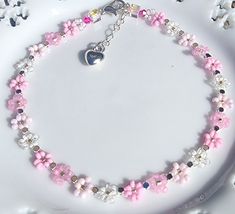 This dainty beaded anklet is made with extra tiny Japanese and/or Czech seed beads in shades of pink and crystal with faceted silvertone beads between the flowers. The ends are finished with square pink faceted glass beads to add extra sparkle. It has a silver filled extension chain with puffed heart charm.  Anklet measures approximately 9.5" with additional 1" extender chain.  Protect from lotions and sprays and excessive contact with water. Diy Choker, Clay Bead Necklace, Charm Anklet, Beaded Anklet, Ankle Jewelry, Bead Choker, Beads Bracelet Design, Puffed Heart, Clay Bead