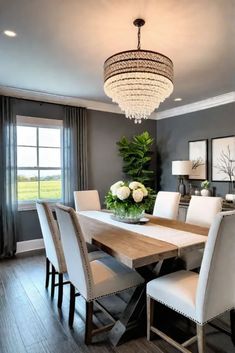 a dining room table with white chairs and a chandelier