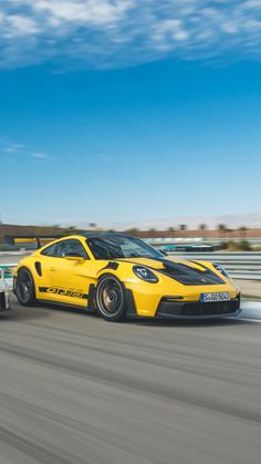 a yellow sports car driving on a race track