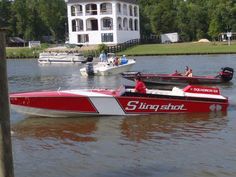 two speed boats in the water near a house