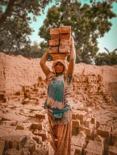 a woman carrying bricks on her head