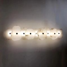 a light that is on the side of a wall with four lights attached to it