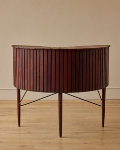 a round wooden table sitting on top of a hard wood floor next to a wall