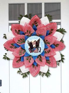 a red white and blue wreath with an eagle on the center is hanging on a door