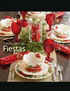 the table is set for christmas dinner with red and white dishes, silverware, and napkins