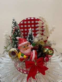 a glass bowl filled with christmas decorations on top of a table