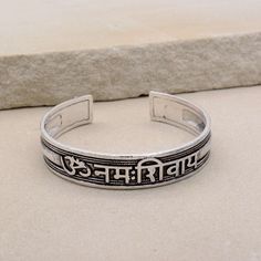 About item Item :-  Kriya Bangles Kada Ring size :- Chose from variation (Custom size accepted) Material  :- German Silver, Brass Title:-Om Namah Shivay Sacred Bracelets, Mantra Bracelet "Aum Namah Shivay "Open Face Cuff Bangle, Sacred Bracelets for Spiritual Bliss, Yoga Gifts, God Shiva bangles, Om Spiritual Jewelry, Valentine's day gift, Christmas day gift Description:- We accept all types of custom & personalized order. Please send us a message if you are interested in a custom creation. What Adjustable Bracelets For Meditation And Festivals, Adjustable Spiritual Bracelets For Festivals, Adjustable Spiritual Cuff Bracelet For Friendship, Silver Spiritual Bangle For Festivals, Adjustable Symbolic Bangle Bracelet, Handmade Adjustable Spiritual Bangle, Spiritual Festival Bangle Cuff Bracelet, Spiritual Friendship Cuff Bangle Bracelet, Spiritual Friendship Cuff Bracelet