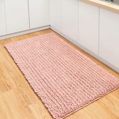 a pink rug on the floor in a kitchen