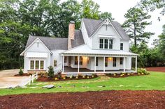 a large white house sitting on top of a lush green field