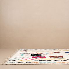 a white rug with multicolored designs on it