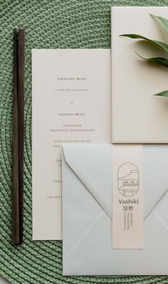 the wedding stationery is laid out on top of an envelope, with a succulent plant next to it