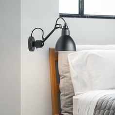 a black lamp is on the side of a bed