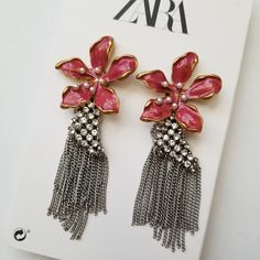 two pairs of pink and silver earrings on top of a white card with an advertise