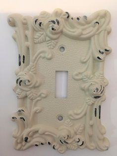 an ornate light switch plate cover in white